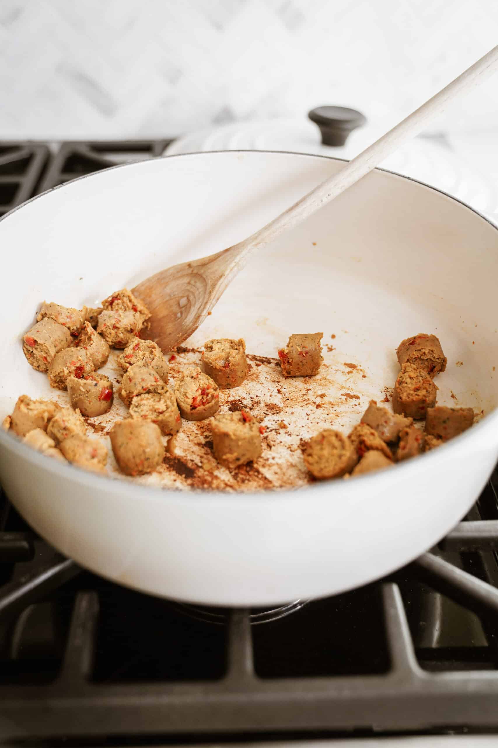 Vegan sausage browning in a pot