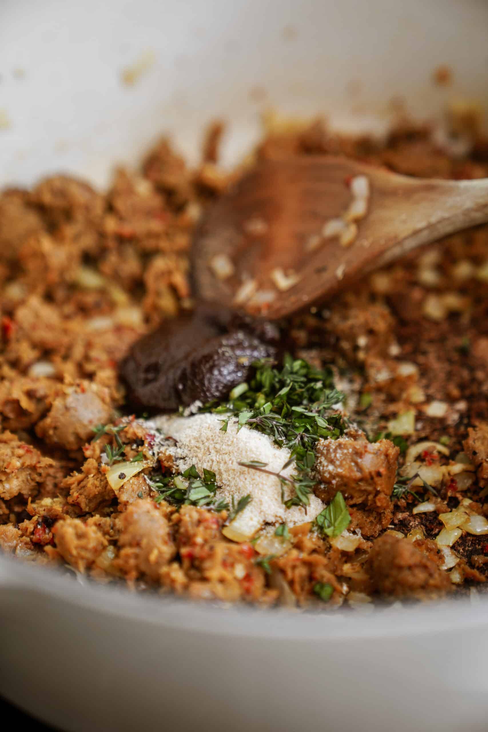 Herbs added to vegan tortellini soup 