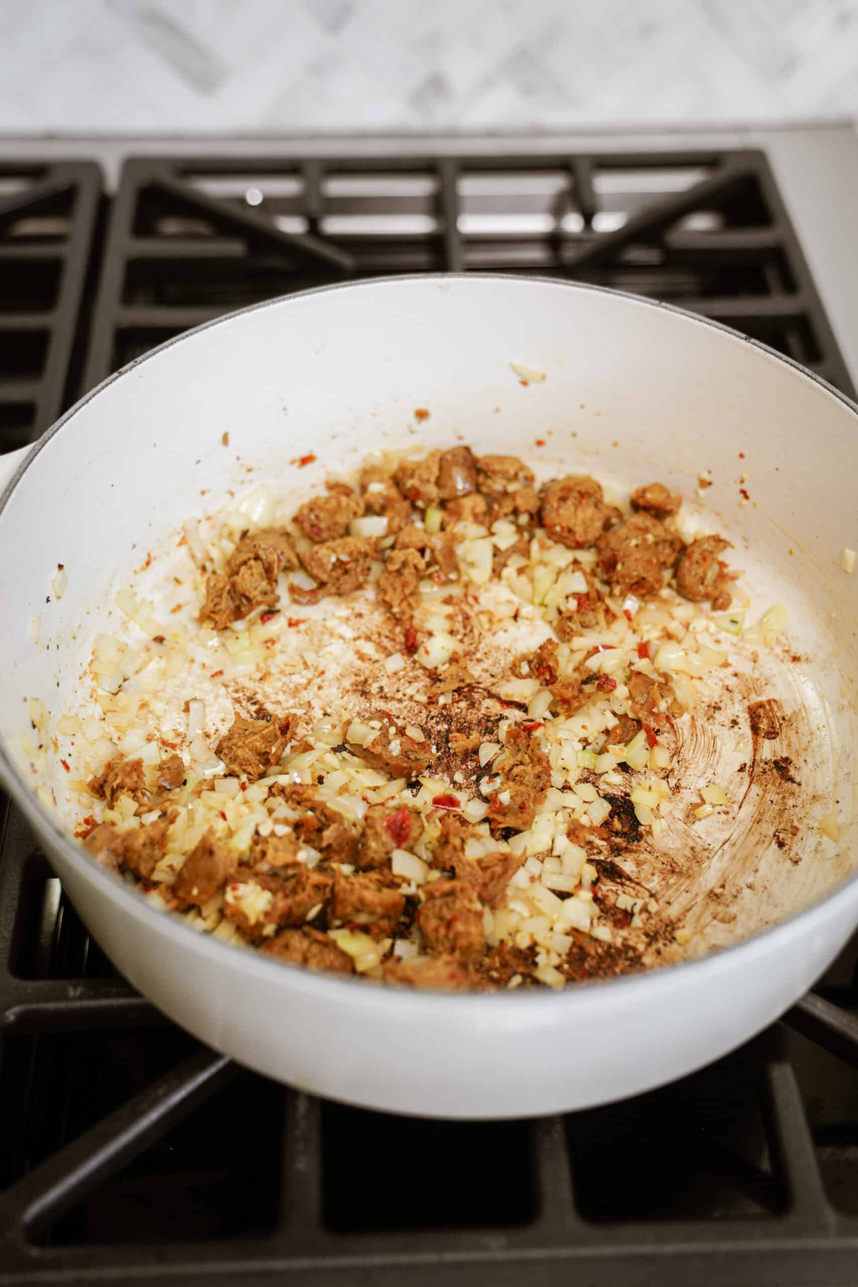 Sausage & onion cooking in a pot on a stove