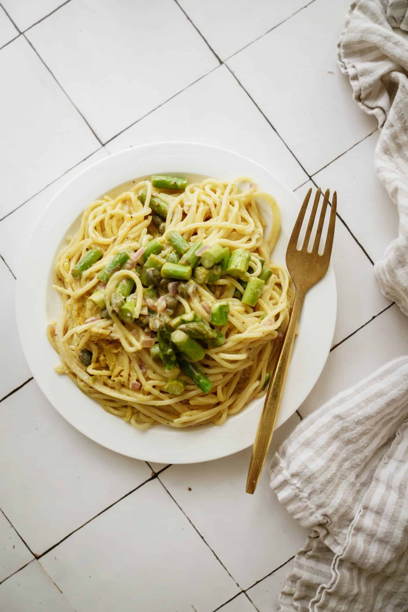 Lemon asparagus pasta on a white plate with a fork