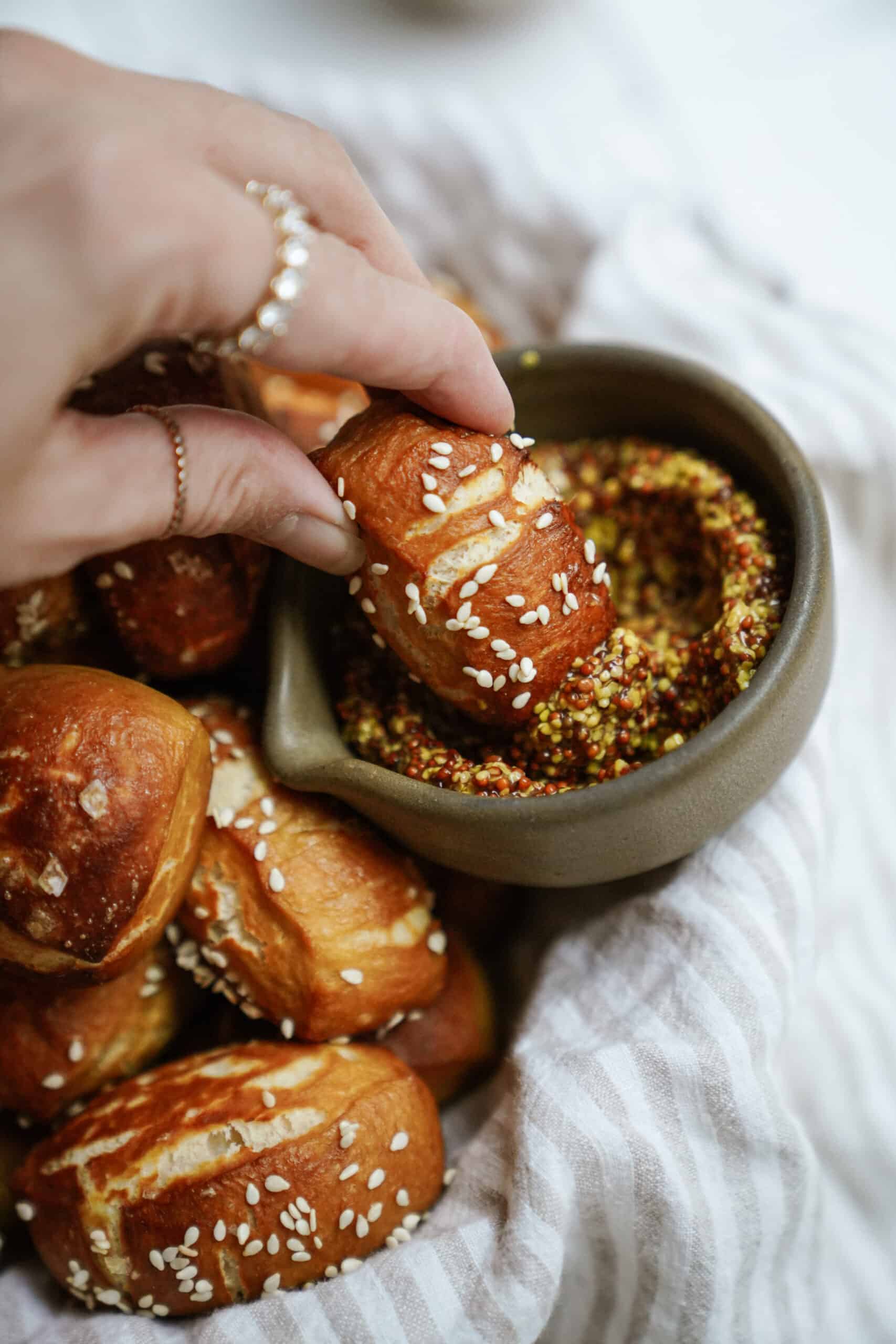 Pretzel bite being dipped into mustard