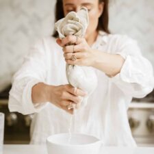 Maria making barista oat milk in a bowl