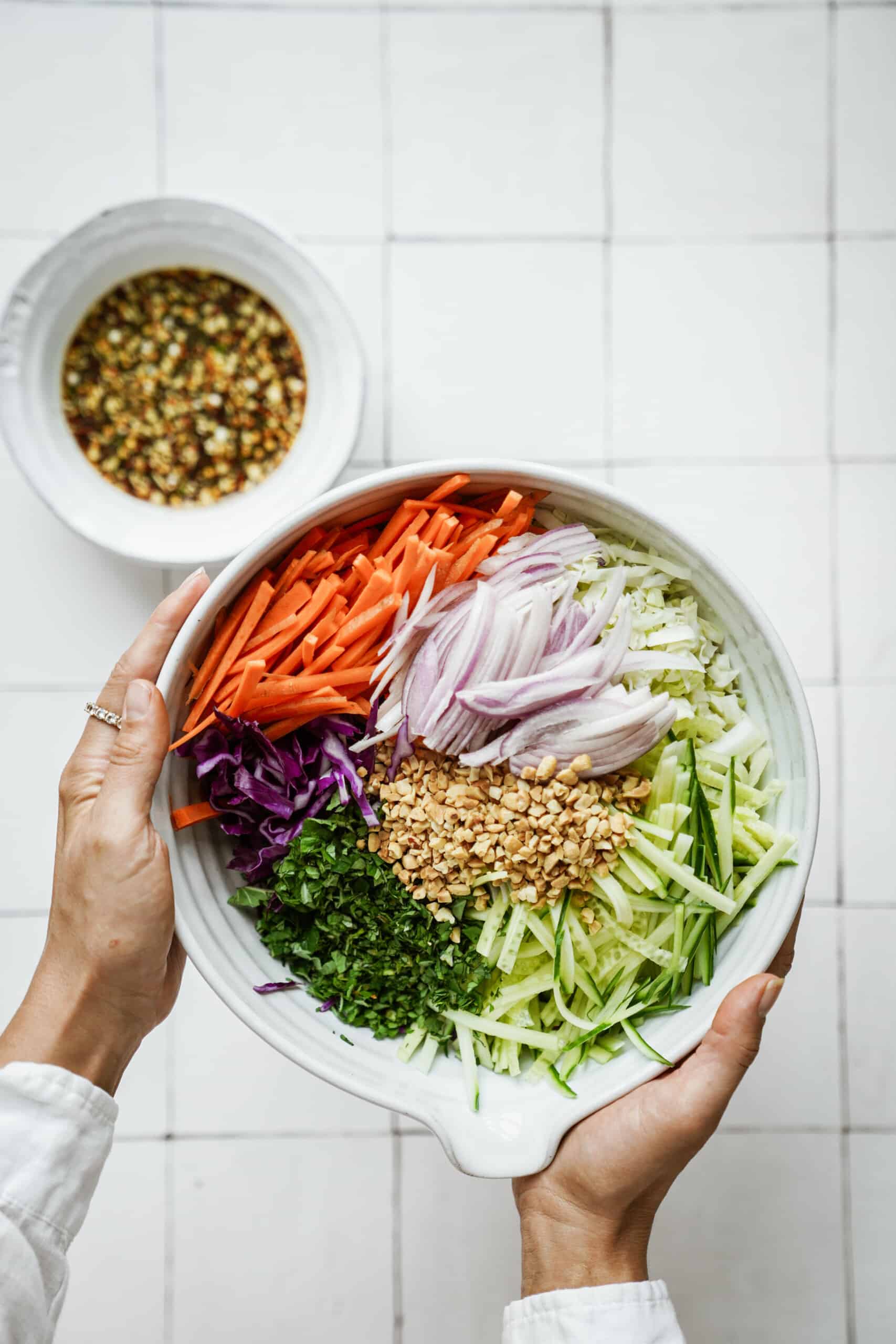 Hand holding cabbage salad in a bowl