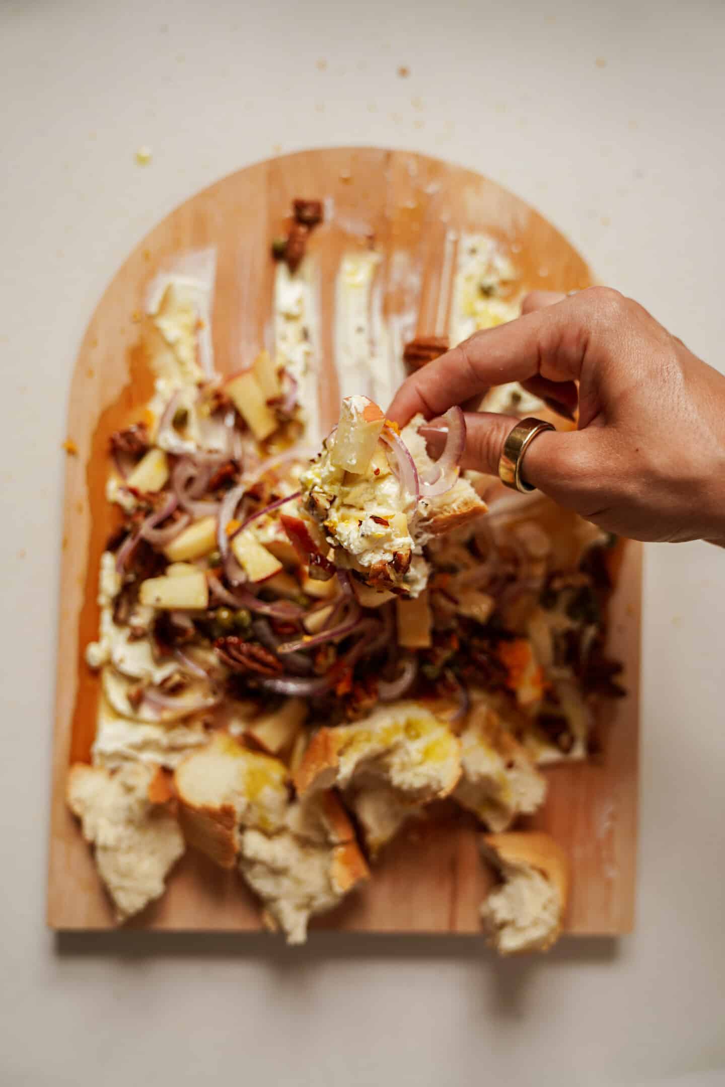 Cheese board with hand picking off toppings