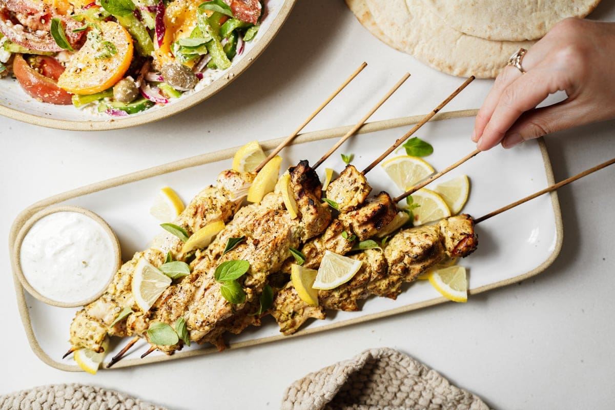 Greek chicken souvlaki on skewers on a plate