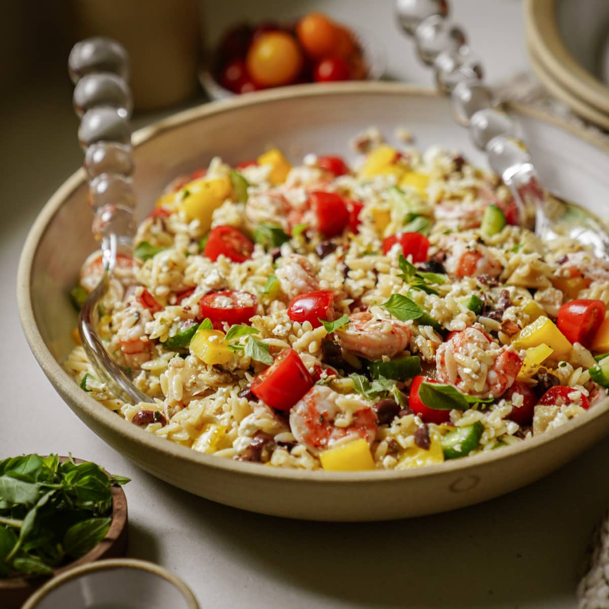 Serving bowl with spoons of Greek Orzo Salad