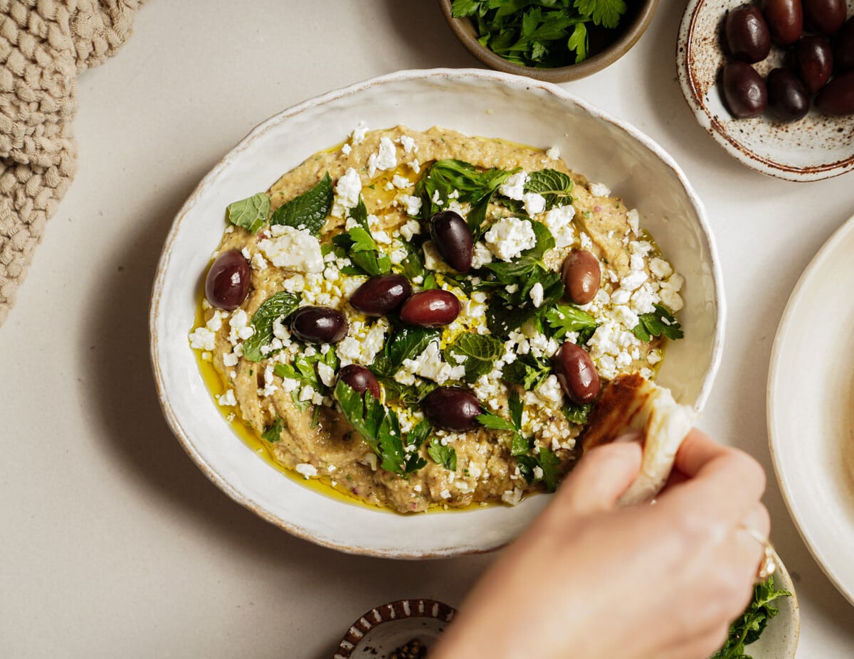 Whipped eggplant dip with a pita dipping into it