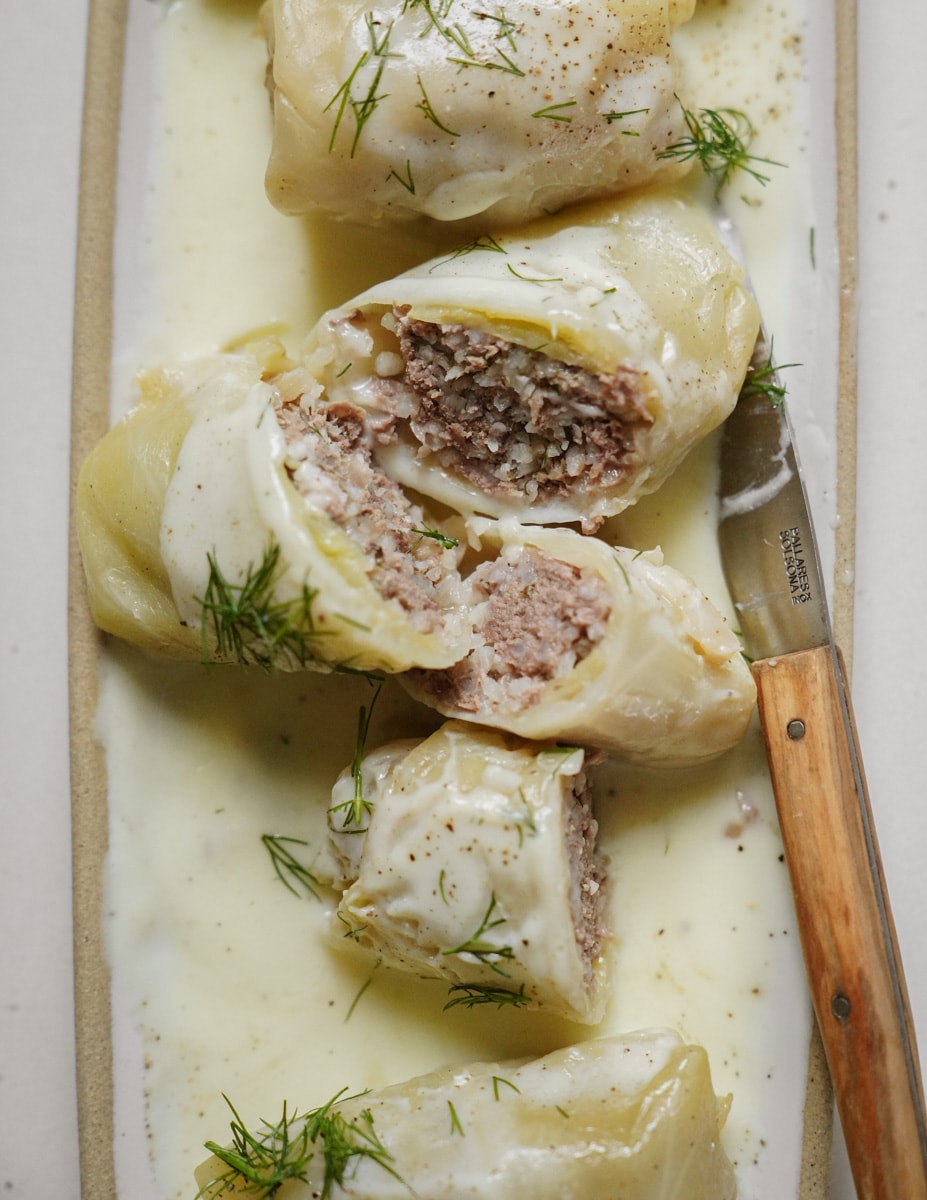 Cut open cabbage rolls on a plate with a knife