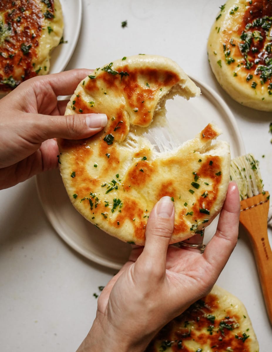 Hand tearing a part a fluffy pita bread