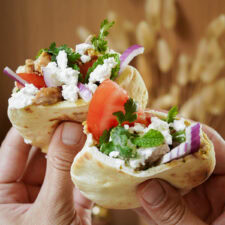 Marinated Chicken Thighs in Mini Pitas being held by hands