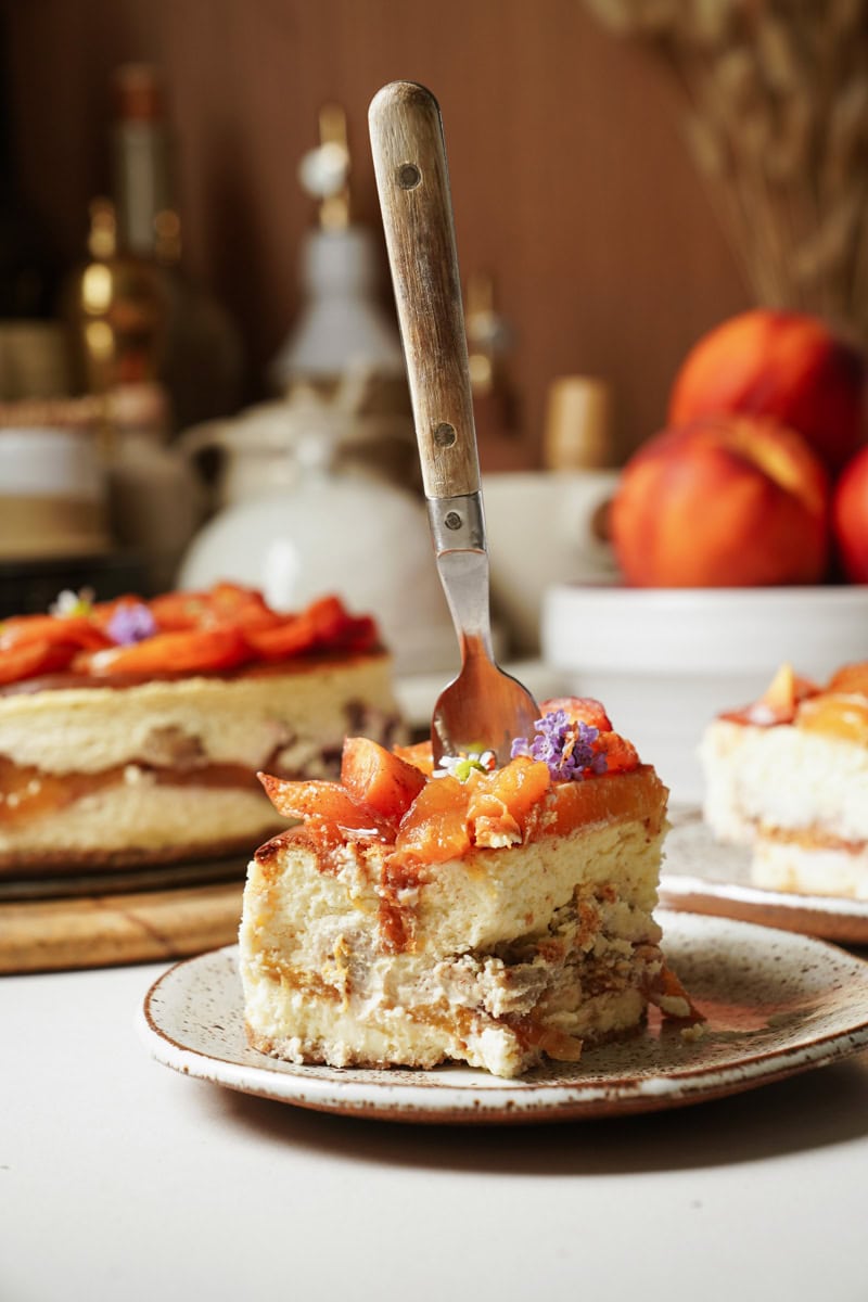 Slice of Peach Cobbler Cheesecake with a fork in it 