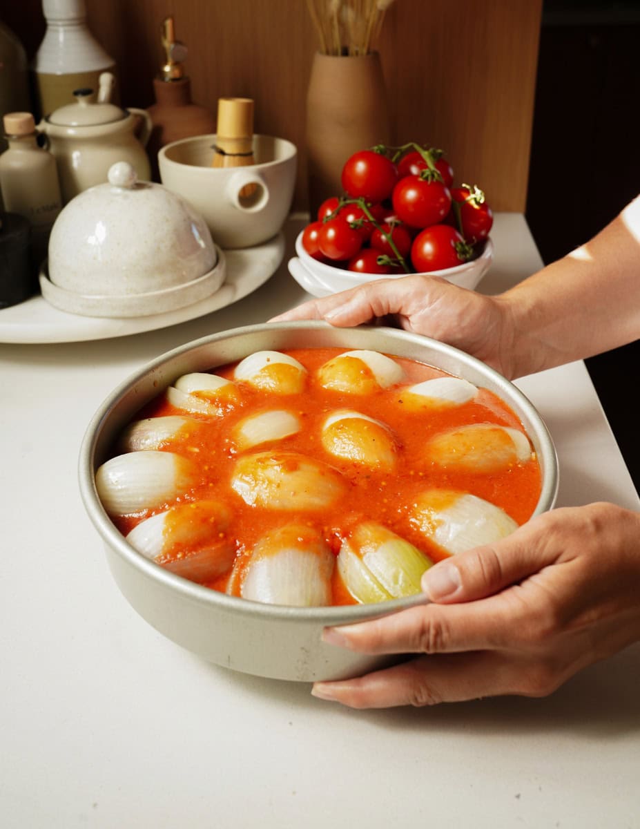 Pan of stuffed onions with hands holding it