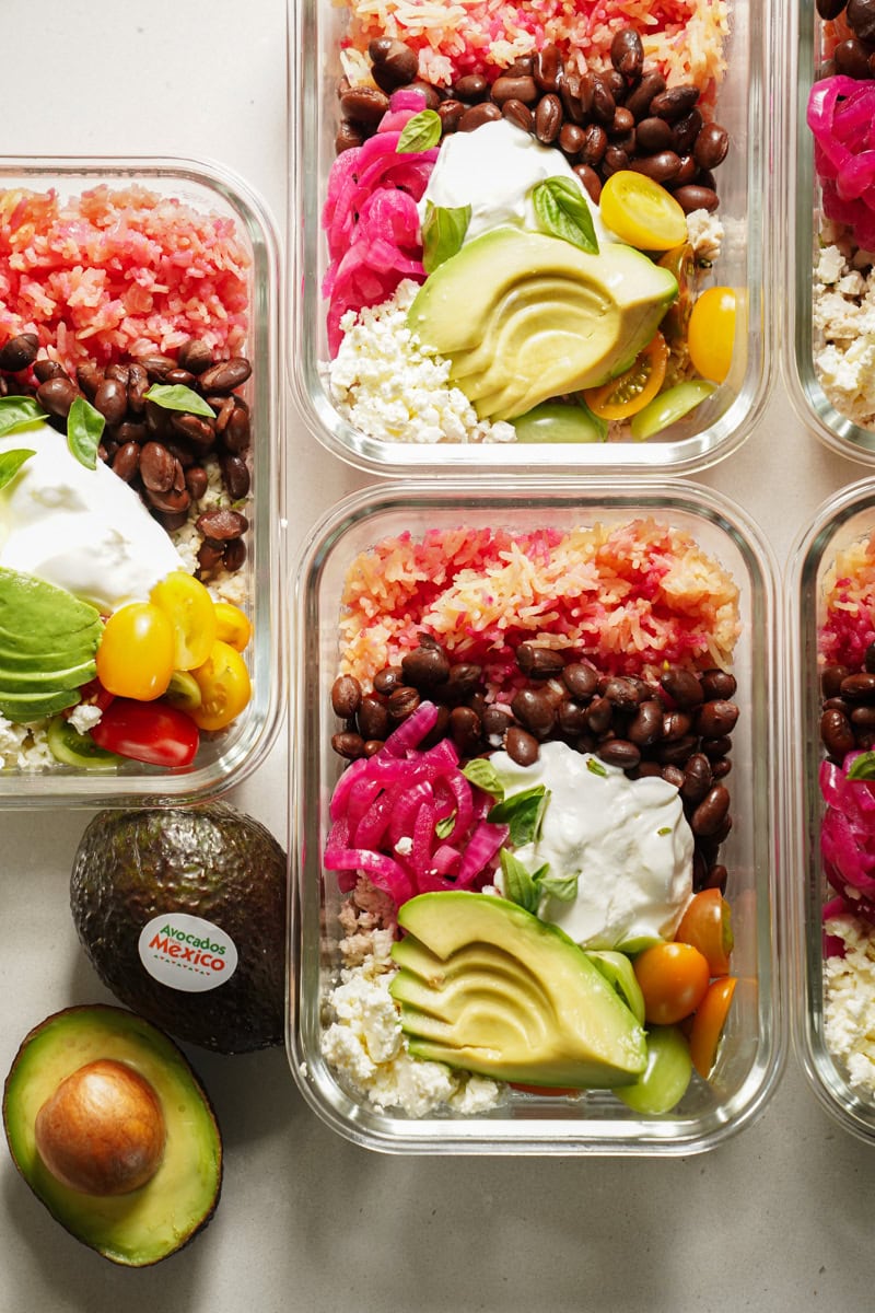 Chicken rice bowls prepped in containers on a counter