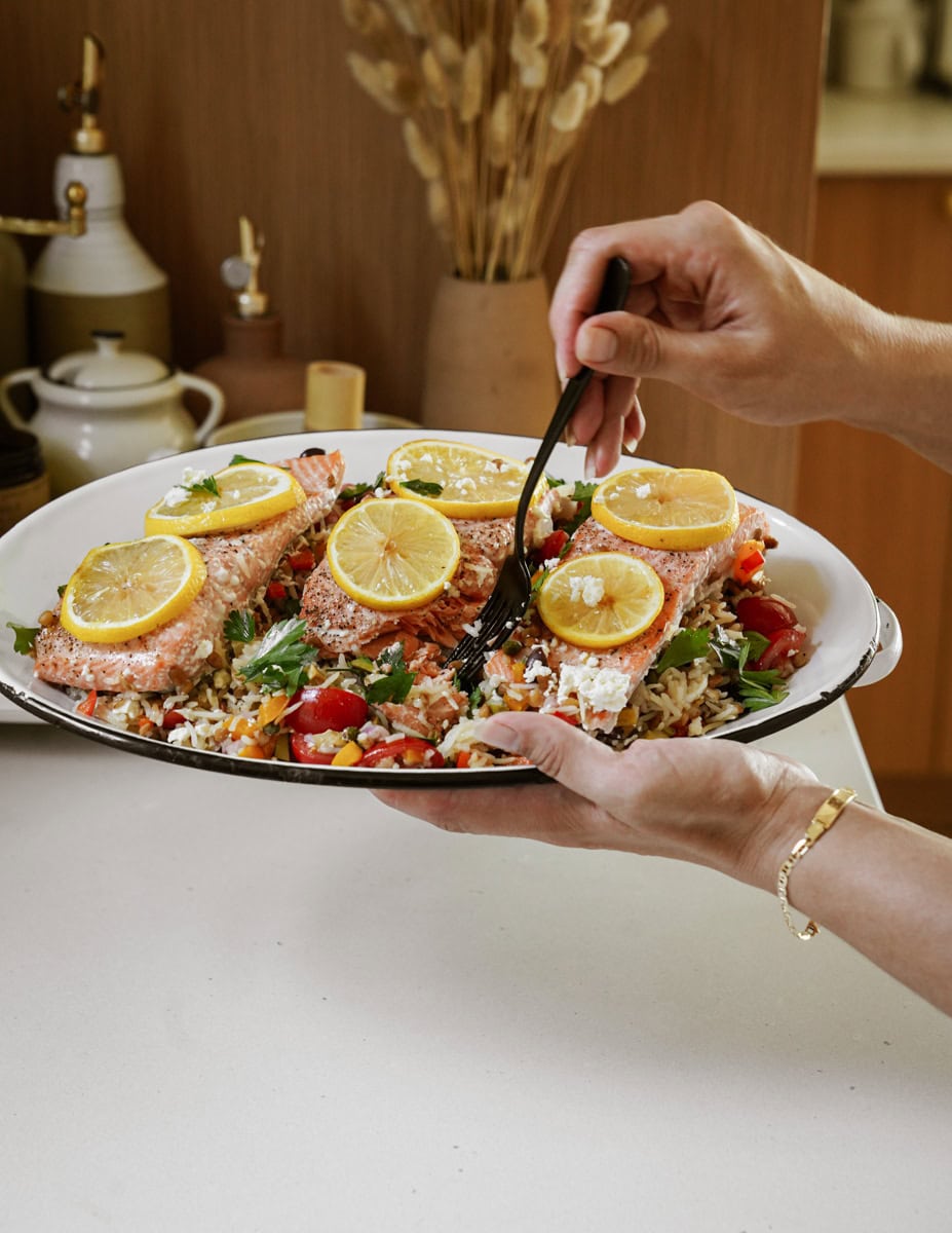 Fork digging into oven baked rice and trout